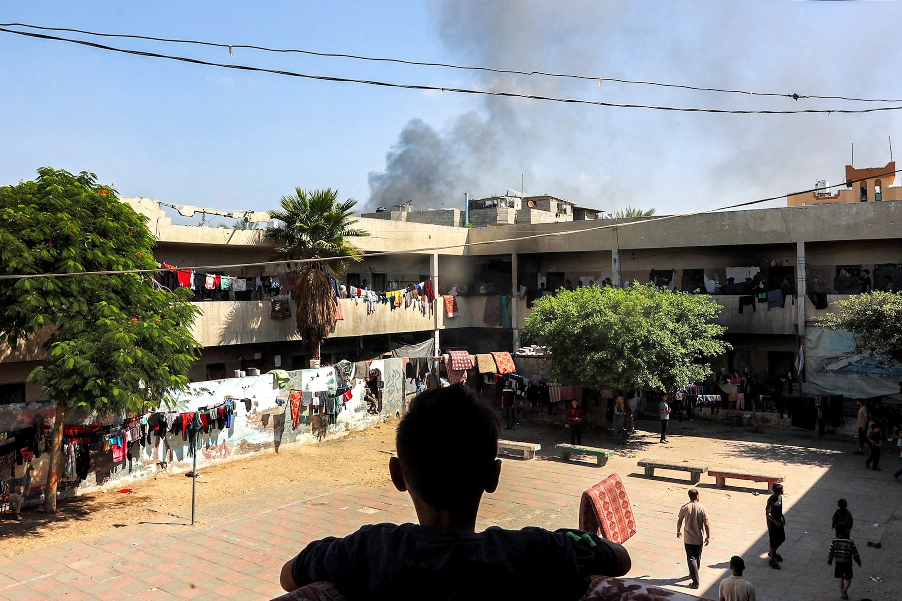 PHOTO: A boy watches a smoke plume rise while standing in the balcony of the Rafei school, being used as a displacement shelter, in the Jabalia camp for Palestinian refugees in the northern Gaza Strip on Oct. 9, 2024.